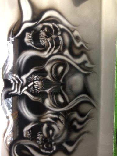 Three stylized skulls with detailed features and tribal elements.