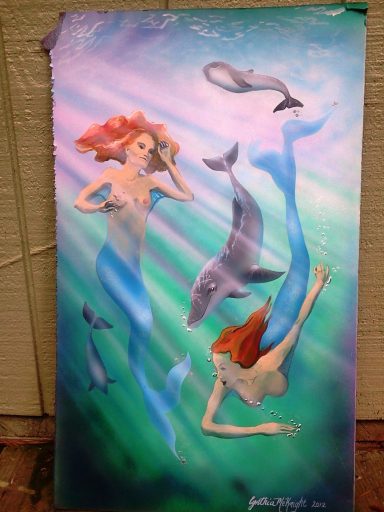 Two mermaids swim with dolphins in a vibrant underwater scene.
